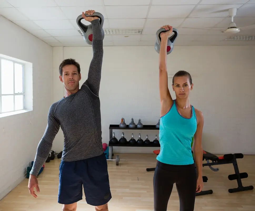 Egy nő és egy férfi kettlebellel edz