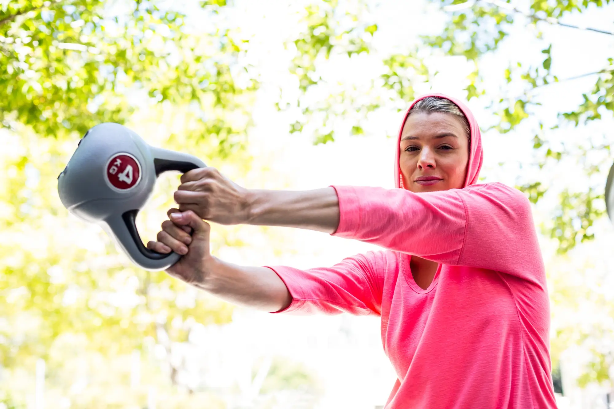 Kettlebell gyakorlatokat végző nő a szabadban