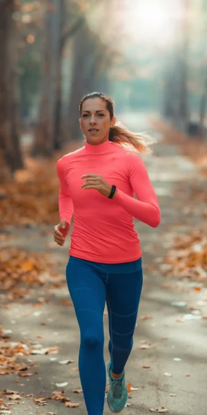 Csinos nő könnyed mozgással fut az erdőben